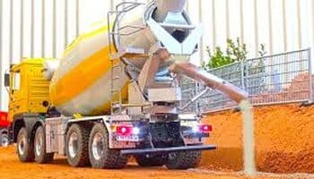 An image of Concrete mixer truck pouring concrete on the road.